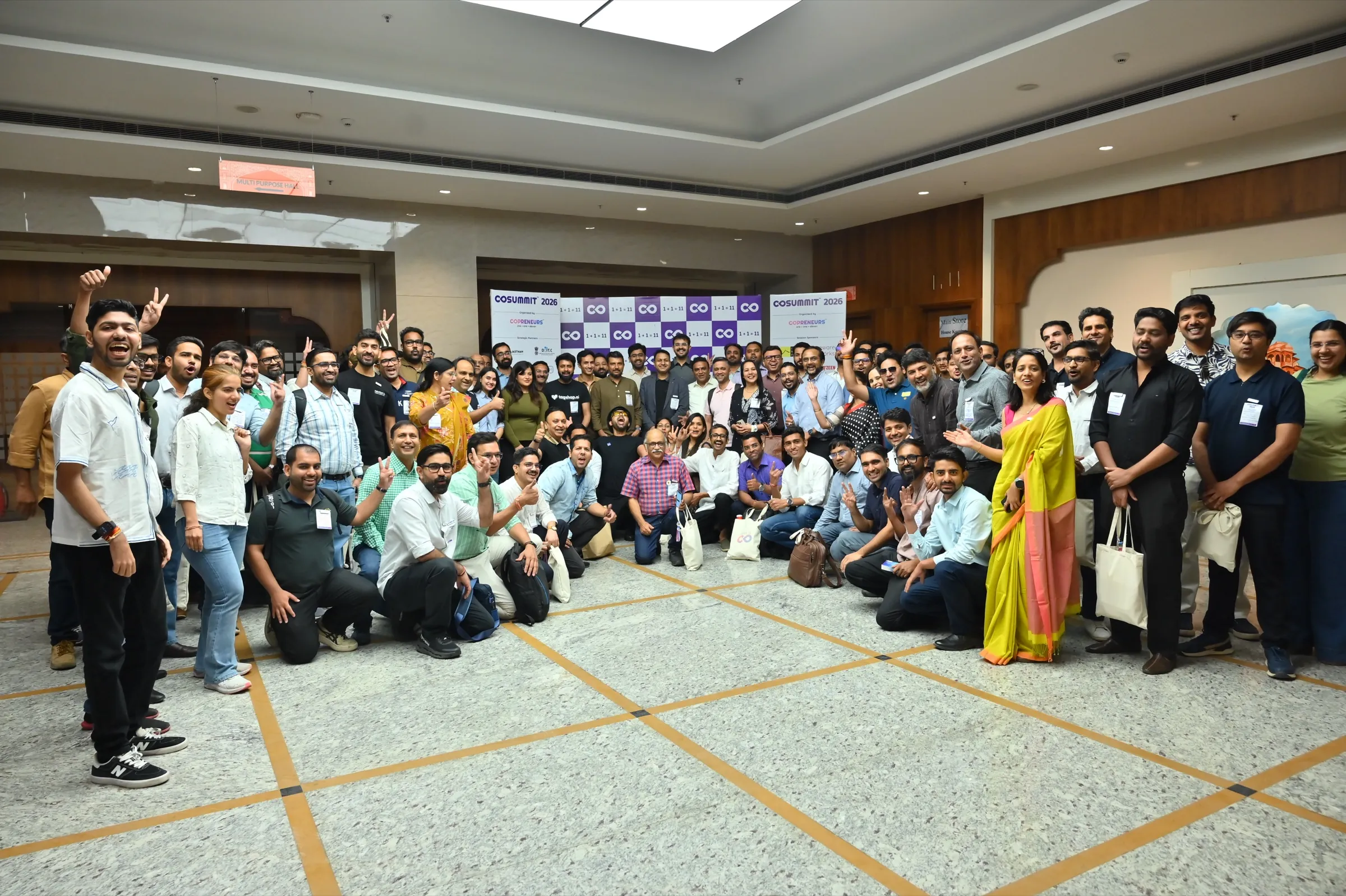 Founders cheering together in a group photo at CoSummit 2026